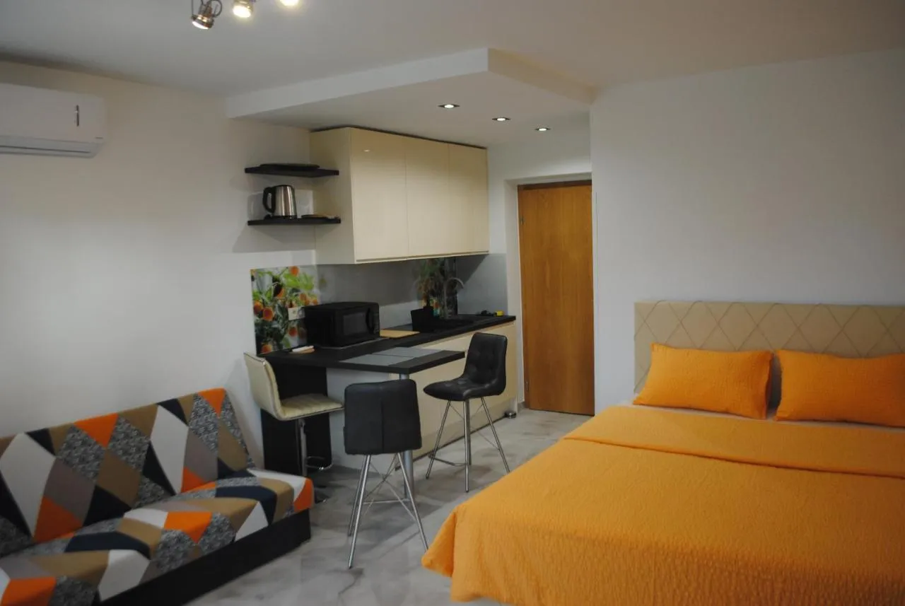 Studio Mandarina z oranžno posteljo in kuhinjskim pultom