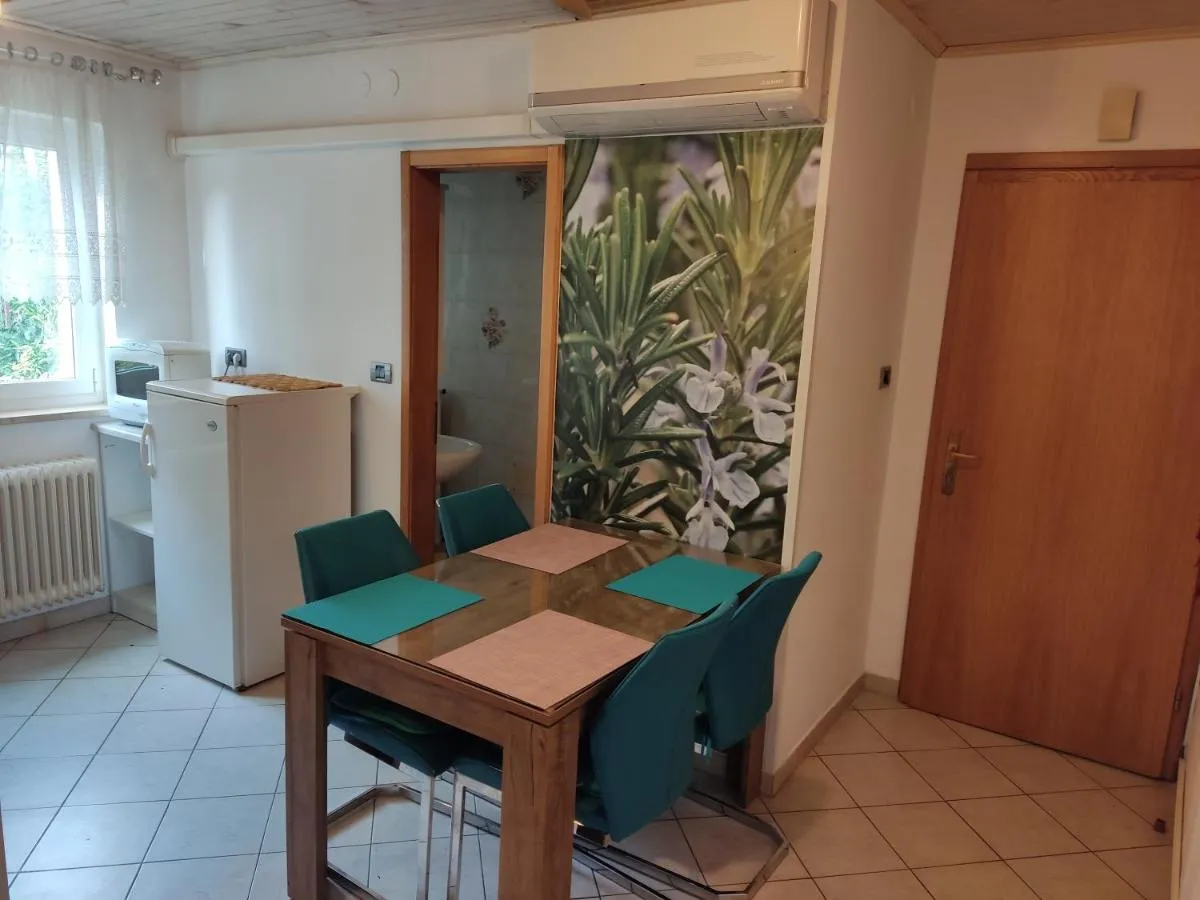 Jedilna miza v apartmaju Rožmarin, za njo stena z rožmarinom