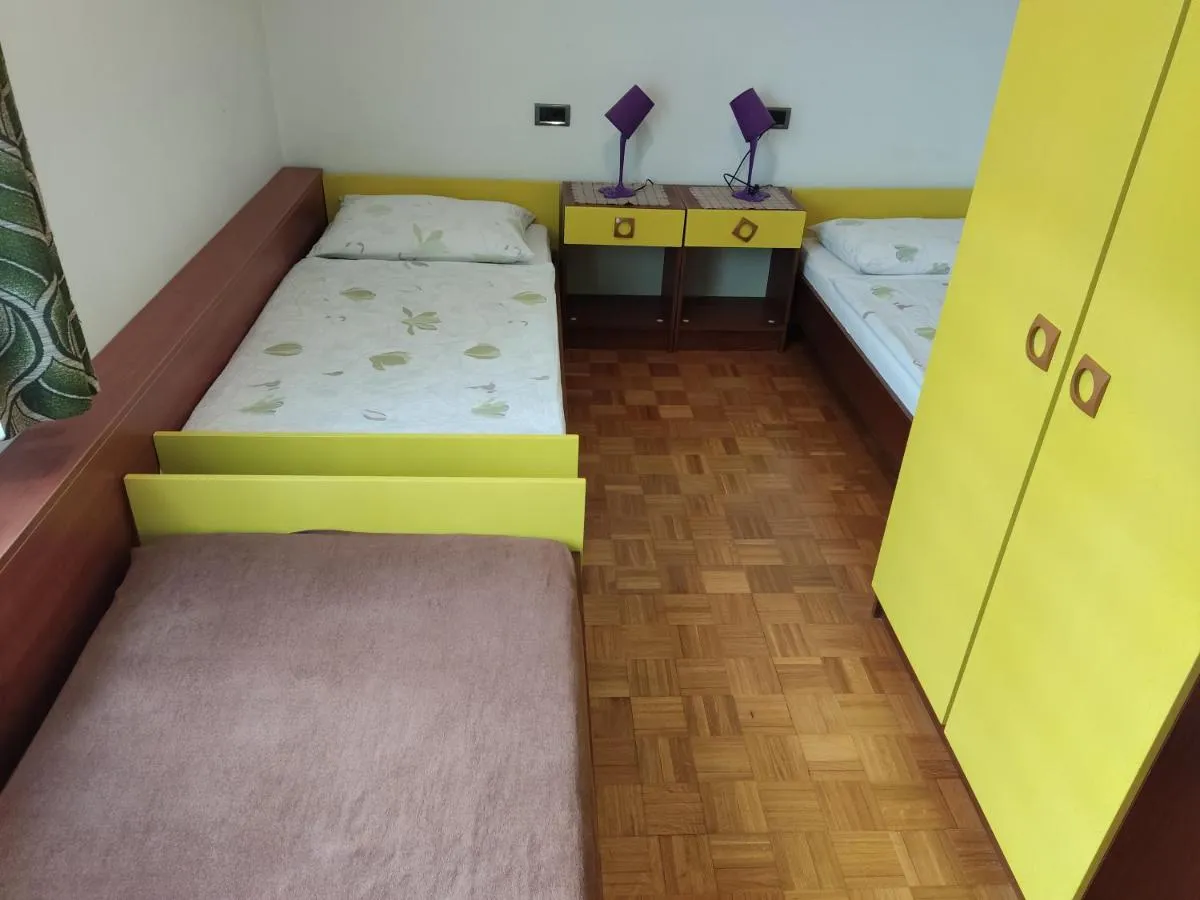 Soba s tremi enojnimi posteljami v apartmaju Rožmarin